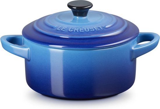 Gegradueerde blauwe mini-braadpan met deksel en zwarte knop, Le Creuset logo zichtbaar.