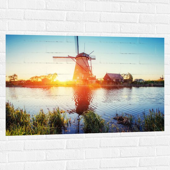 WallClassics - Muursticker - Zonlicht langs Hollandse Molen aan het Water - 105x70 cm Foto op Muursticker