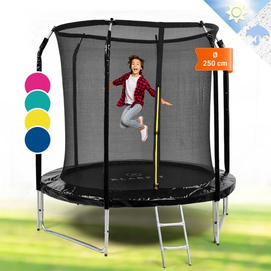 Jongen met geruit shirt springt op een zwarte trampoline van 250 cm doorsnede, met ladder en veiligheidsnet.