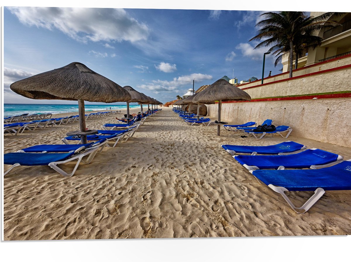 PVC Schuimplaat- Blauwe Ligbedden op Strand met Rieten Parasols - 75x50 cm Foto op PVC Schuimplaat