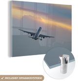 MuchoWow® Glasschilderij 150x100 cm - Schilderij acrylglas - Vliegtuig dat richting de zonsondergang vliegt - Foto op glas - Schilderijen