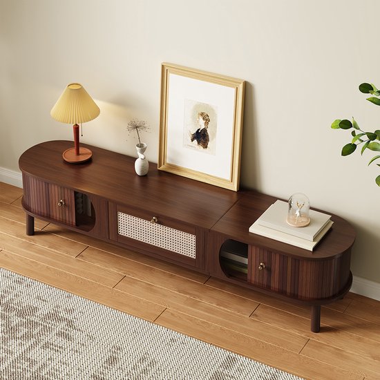 Donkerhouten tv-meubel met ronde vormen, rieten middenlade en messing knoppen.