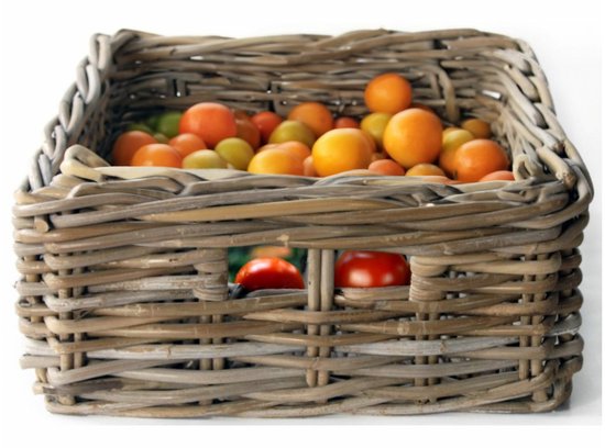 Gevlochten rotan mand gevuld met diverse tomaten en sinaasappels.