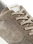 Close-up van een taupe suède sneaker, focus op de veters en Rehab logo op de tong.