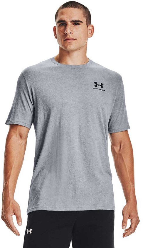 Man in een grijs Under Armour t-shirt met korte mouwen en een zwart logo op de borst.