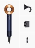 Blauwe Dyson haardroger met koperkleurige ring, naast drie accessoires.