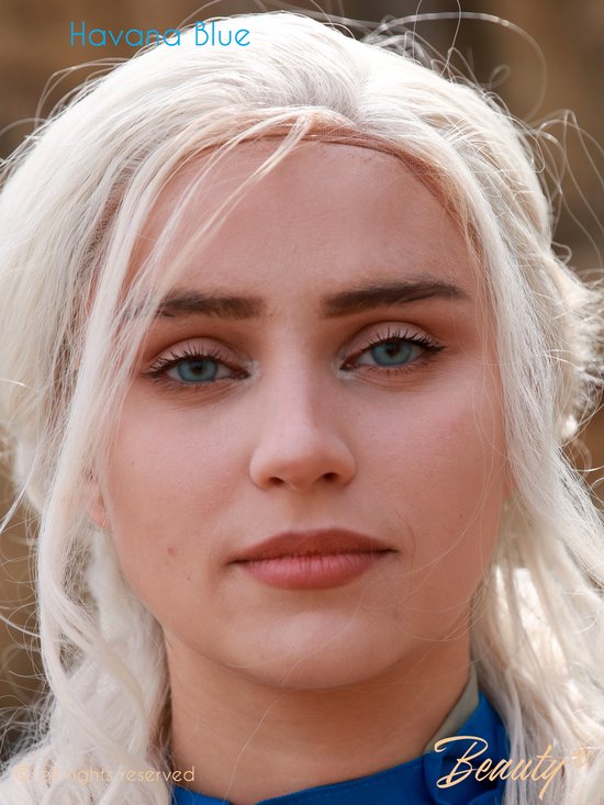 Een vrouw met lang wit haar en opvallende blauwe ogen met een subtiele oogmake-up. "Havana Blue" is zichtbaar.