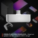Witte USB-C dongle met Steelseries logo omringd door game-apparaten.
