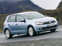 Lichtblauwe Volkswagen Golf 6 rijdt op een weg.