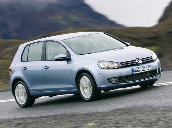 Lichtblauwe Volkswagen Golf 6 rijdt op een weg.