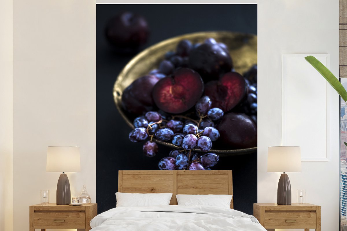 Behang - Fotobehang Gouden kom met paarse druiven in het donker - Breedte 145 cm x hoogte 220 cm