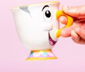 Une main tient un mug blanc avec le visage de Chip, anse orange et base colorée.