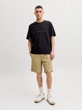 Zwarte t-shirt met korte mouwen en ronde hals. Tekst "JACK & JONES" op de borst. Gedragen door een Aziatische man met een bruine short.