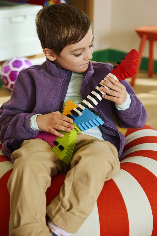 Een jongen met een paarse trui speelt met een kleurrijke LEGO-gitaar.