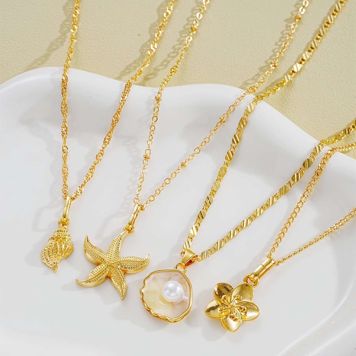 Sjika - Dames Ketting Goudkleurig met Zee Bedel – Schelp, Zeester, Parel & Bloem Hanger – Trendy Zomer Halsketting – Beach Sieraden - Cadeau voor haar