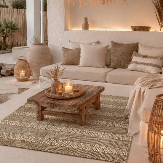 Tapis rayé sur une terrasse avec un canapé, une table basse et des lanternes.