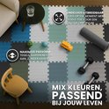 Een speelse vloer van puzzelmatten in verschillende kleuren blauw, grijs, groen en crème. Speelgoed en meubels staan op de mat.