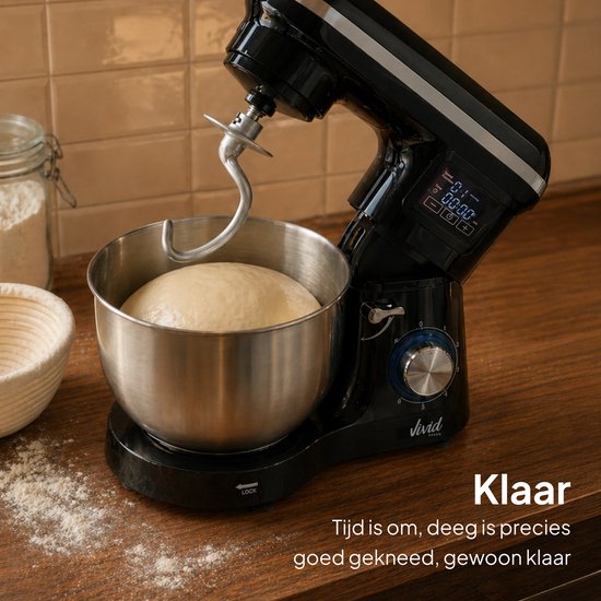 Zwarte keukenmixer met metalen kom met deeg, klaar voor gebruik, met wat bloem op het aanrecht.