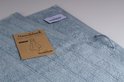 Deux serviettes bleu clair avec étiquette et carte indiquant 'Serviette 50 x 100'.
