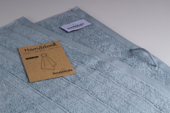 Deux serviettes bleu clair avec étiquette et carte indiquant 'Serviette 50 x 100'.