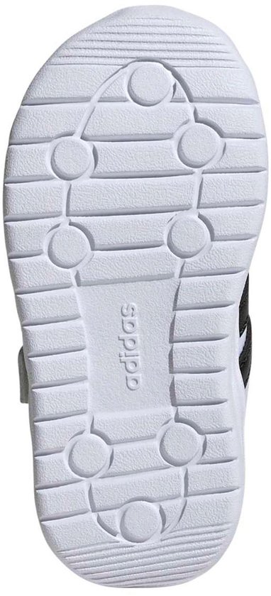 Onderkant van een witte kindersneaker met Adidas logo.