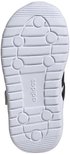 Onderkant van een witte kindersneaker met Adidas logo.