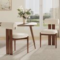 Twee beige eetkamerstoelen met houten frame met zicht op een parklandschap door een raam.
