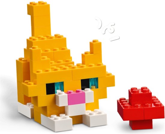 Een LEGO-kat in het geel met blauwe ogen, een roze snuit en een witte snuit, naast een rode paddenstoel.