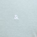 Detail van de kraag van een lichtgroene polo met groen-witte streepjes en witte knopen.