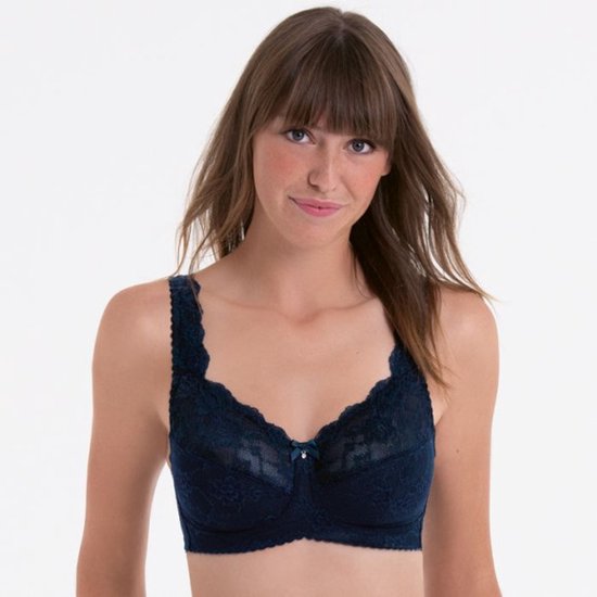 Vrouw met bruin haar draagt marineblauwe kanten bh, strikje met kristal, kanten rand.
