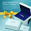 Een luxe geschenkdoos met een open deksel en een blauwe binnenkant. De ring ligt in de doos, met een gele strik en een certificaat ernaast.