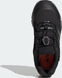Bovenkant van zwarte kinderschoen met veters, GORE-TEX-logo en Adidas-strepen.