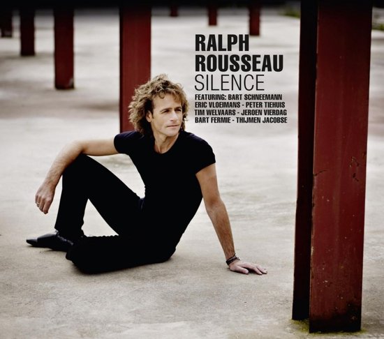 Ralph Rousseau zit op de grond in een zwarte outfit, met tekst 'Ralph Rousseau Silence'.
