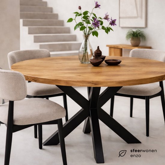 Ronde mangohouten eettafel met stalen matrix onderstel, omringd door vier stoffen stoelen.