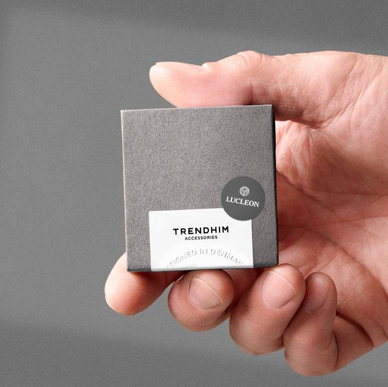 Hand houdt een klein grijs doosje met 'TRENDHIM ACCESSORIES' en 'LUCIEN' logo.