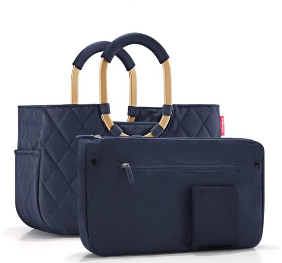 Donkerblauwe shopper met ruitpatroon en goudkleurig frame, naast een donkerblauwe etui met rits.