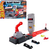 Een doos Hot Wheels F1 racebaan met twee F1-auto's, de racebaan zelf, en extra onderdelen. Zwarte F1-auto's met rode en grijze accenten.