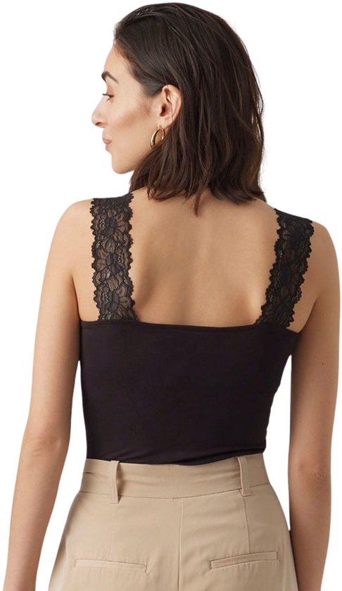 Achterkant van een zwarte top met kanten schouderbandjes, gecombineerd met een beige broek.