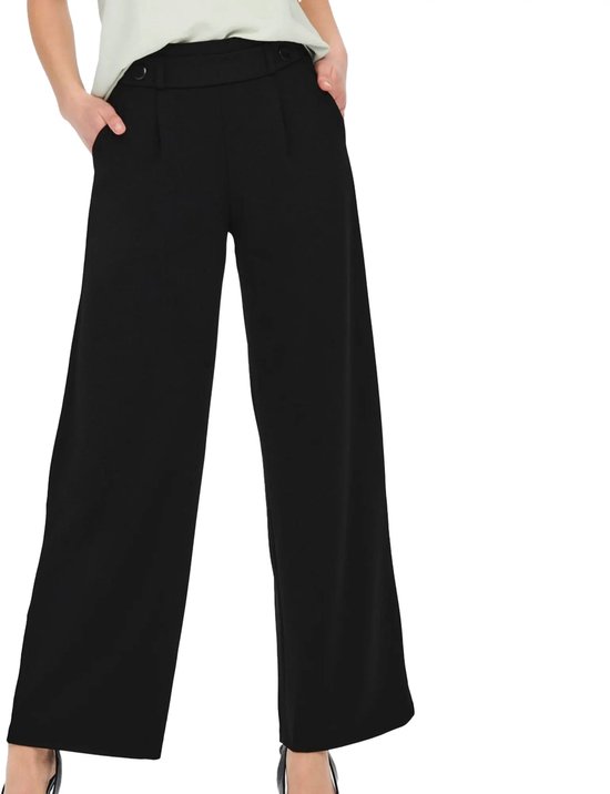 Model draagt zwarte wijde broek met hoge taille.