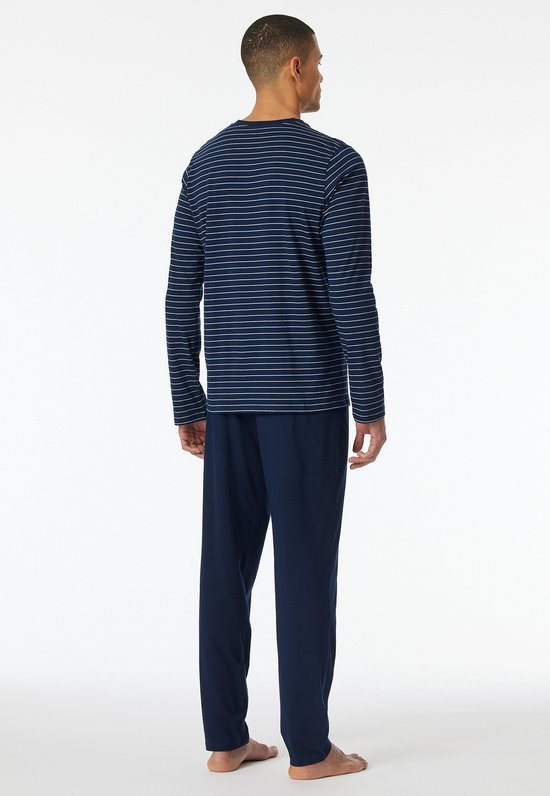 Man van achteren in lang pyjamaset van donkerblauw met fijne witte strepen en effen broek.