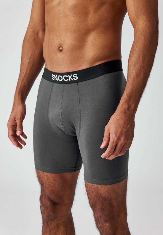 Grijze Snocks boxer met zwarte band en logo, gedragen door een man.