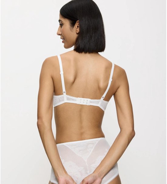 Achterkant van een model met een witte kanten beugel-bh en slip. Handen achter de rug.