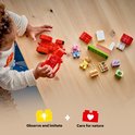 Kind speelt met losse LEGO Duplo Peppa Pig blokken en voertuigen.