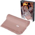 Lichtroze mousseline deken, opgerold, naast de productverpakking.