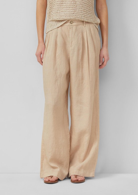 Model draagt een beige gebreide top en een wijde beige linnen broek, zicht op de voorkant.