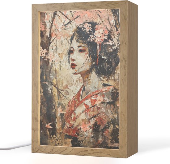 Cadre en bois avec un tableau d'une femme japonaise en kimono, entourée de fleurs de cerisier, avec un éclairage subtil.