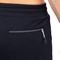 Detail van een donkerblauwe korte broek met zilverkleurige ritssluiting en 'SJS' logo.