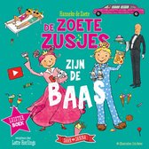 Boekomslag met de titel 'De Zoete Zusjes zijn de baas'. Twee meisjes, een in een roze prinsessenjurk en een in een pyjama, omringd door speelgoed en eten. Rechts een butler.
