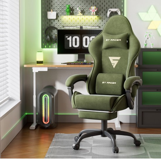 Groene gamingstoel met "ST RACER" logo en helm. Gevuld met kussens en een uitschuifbare voetensteun, staand in een kantoor/game setup.