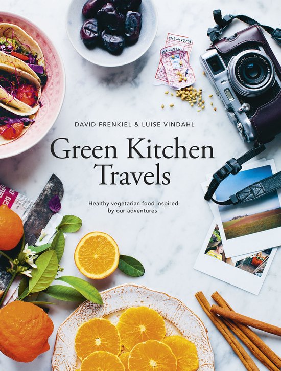 Boek 'Green Kitchen Travels' met David Frenkiel & Luise Vindahl, gezonde vegetarische recepten, sinaasappels, taco's en een camera.